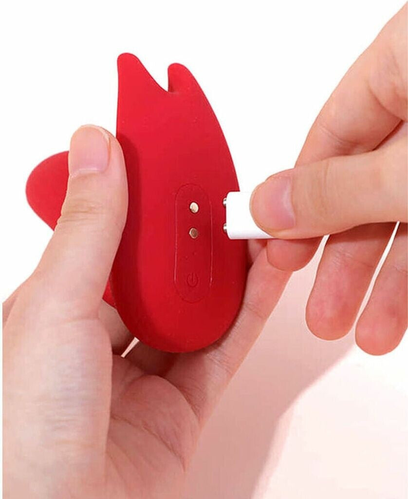 Red silicone tool with a white component being inserted by a hand on a white background