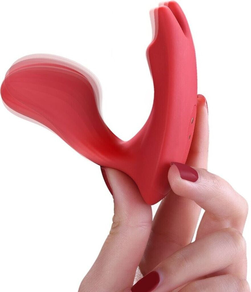 Red silicone device held by a hand with red nail polish on a white background