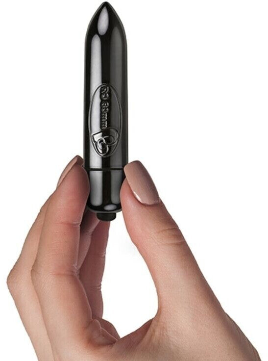 Black lipstick held in a hand against a white background