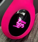 Digital clock with pink case on a dark background