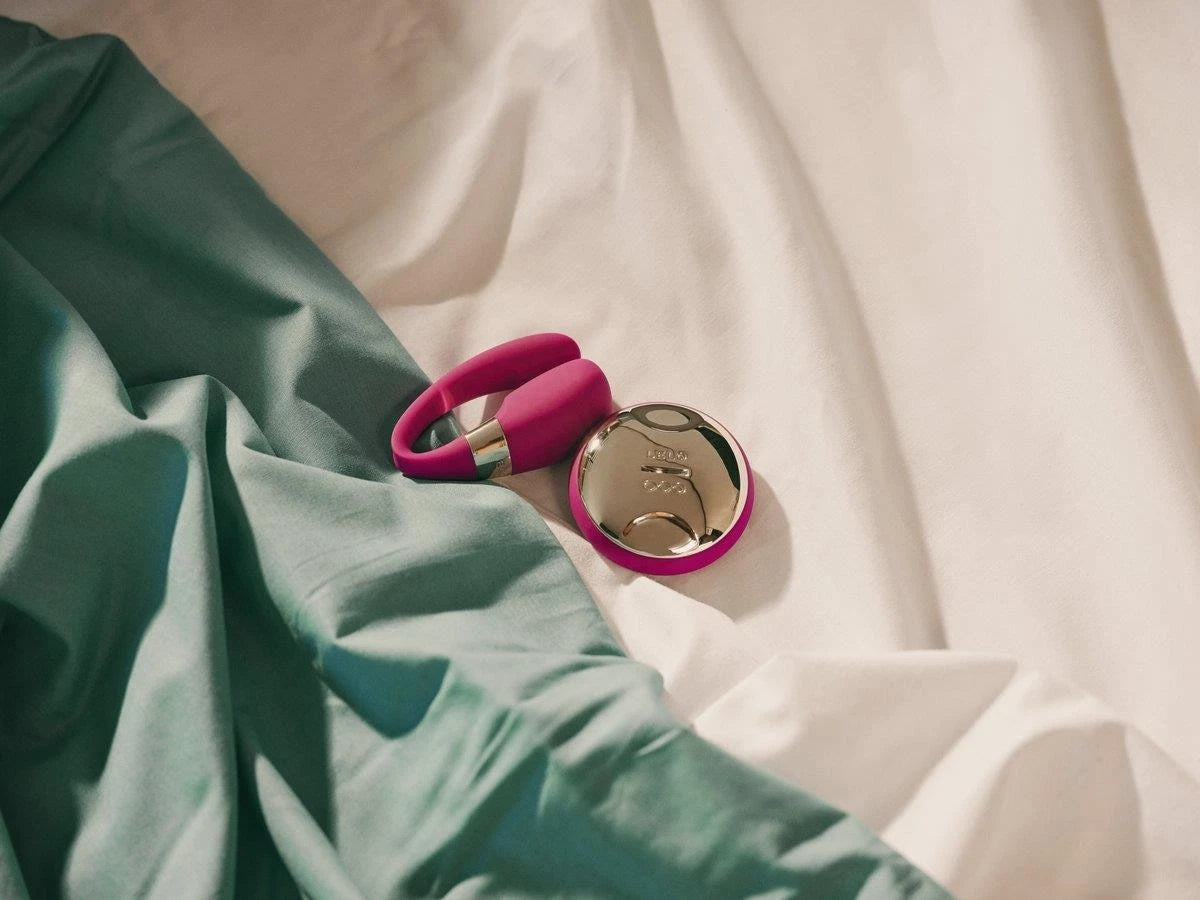 Pink compact mirror on a textured fabric surface