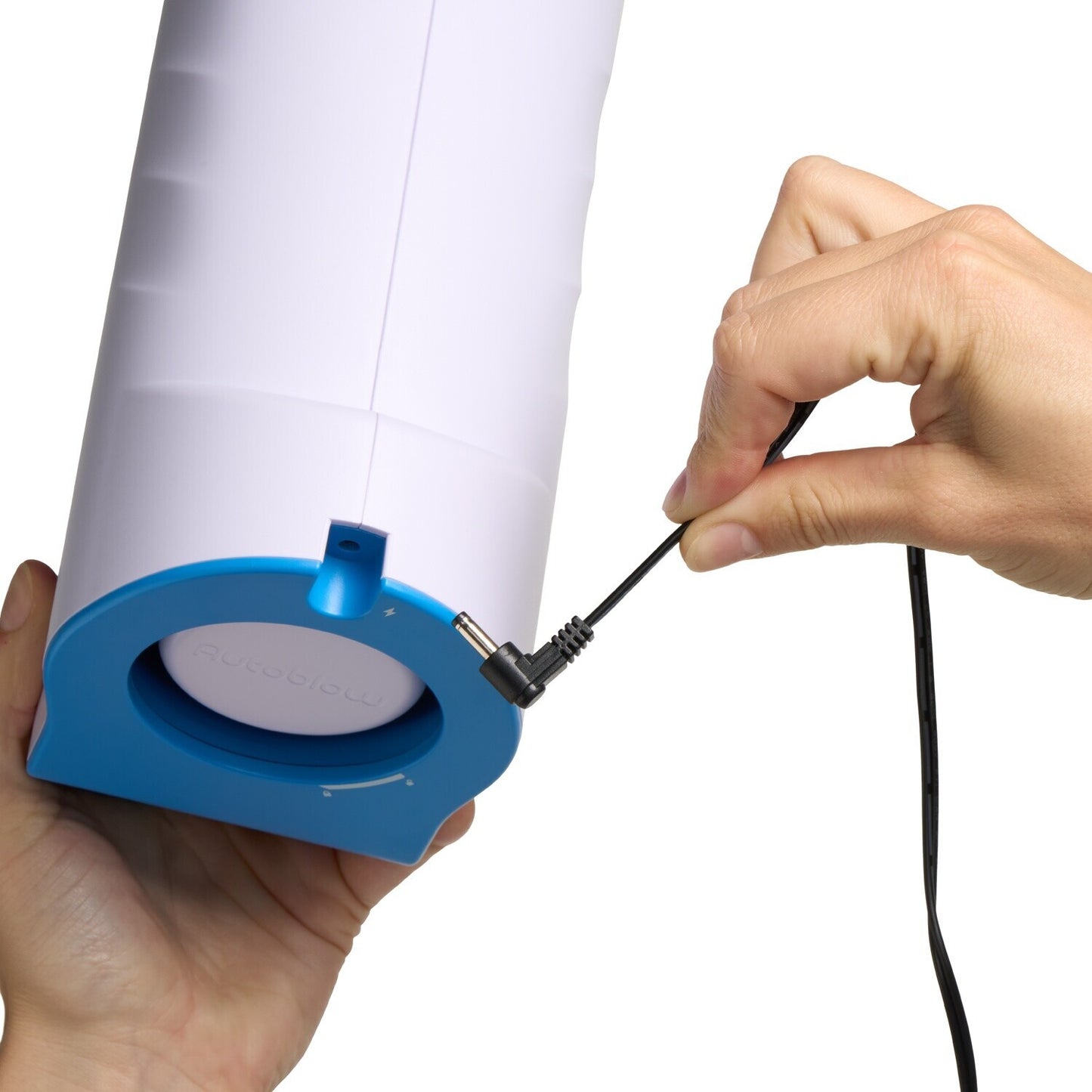 Person holding a cylindrical device with blue base and white top, plugging in a cable.