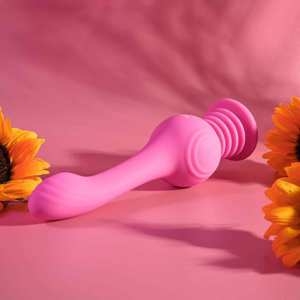 Pink handheld massager on a pink background with sunflowers