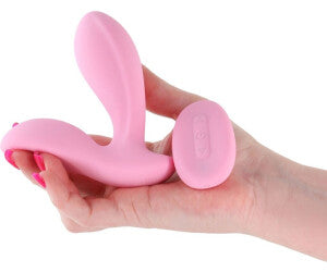 Pink handheld massager held in a hand against a white background
